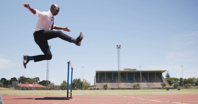 Businessman Jumping Over Hurdle In Stadium - Download Free Stock Images Pikwizard.com