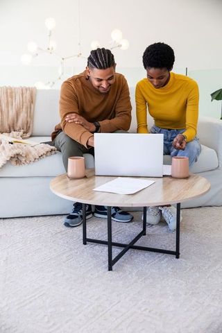 Couple Engaged in Task with Laptop in Cozy Living Room Setting