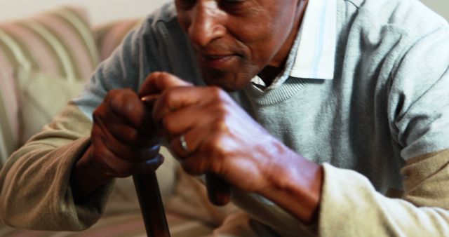 Senior Man Holding Walking Cane at Home on Couch - Download Free Stock Images Pikwizard.com