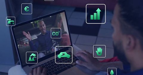 Bearded man watching remote sustainability webinar on laptop with presenter and green icons