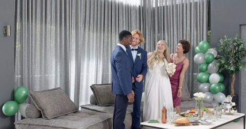 Joyful Wedding Reception With Diverse Friends Embracing Newlyweds Indoors