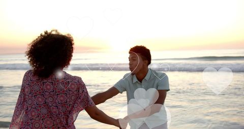 Romantic Couple Embracing on Beach at Sunset With Hearts