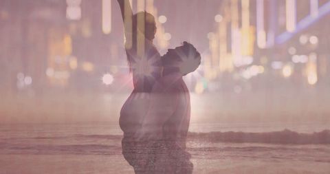Father Lifting Daughter at Beach with City Lights Background