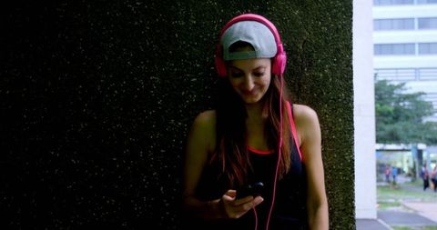 Caucasian Female Street Dancer Using Mobile Phone with Headphones