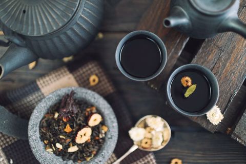 Traditional herbal tea with teapot and dry herbs