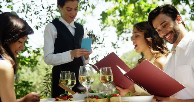 Friends Dining Outdoors While Server Takes Order at Restaurant Table - Download Free Stock Images Pikwizard.com