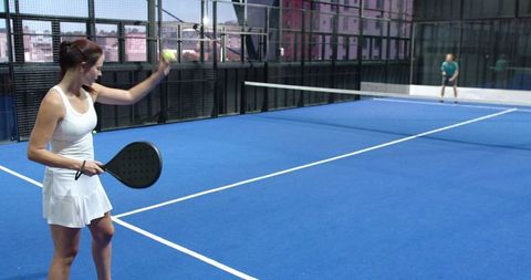 Woman Serving on Modern Padel Court During Competitive Doubles Match