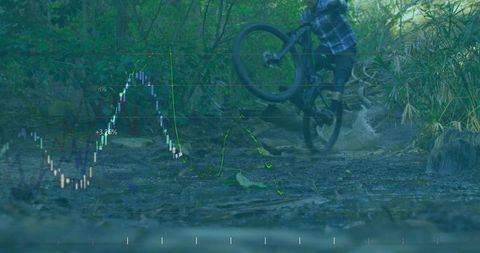 Mountain biker lifting front wheel over muddy stream on forest trail with financial chart overlay