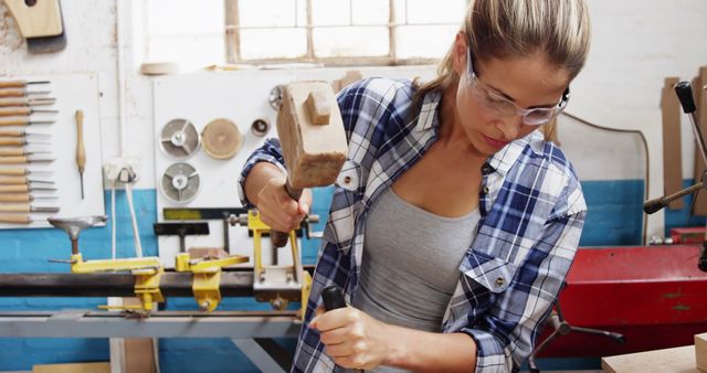 Female carpenter using mallet and chisel in workshop - Download Free Stock Images Pikwizard.com