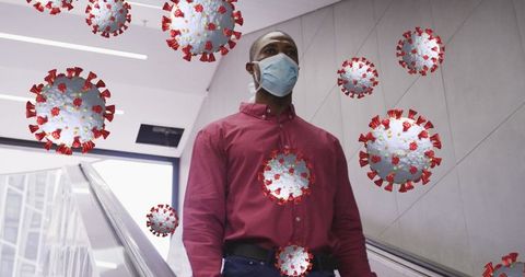 Man wearing mask while using escalator with floating virus cells