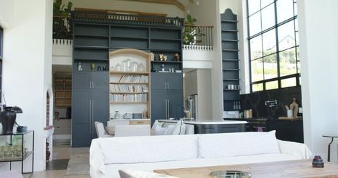 Bright open-plan living room with white sofa and dark gray built-in cabinetry