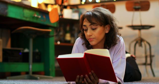 Relaxed Woman Reading Book on Cozy Carpet in Rustic Room - Download Free Stock Images Pikwizard.com