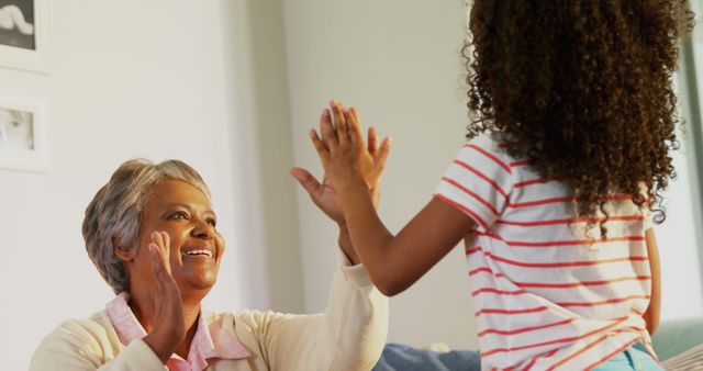 Senior Woman High-Fiving Granddaughter at Home - Download Free Stock Images Pikwizard.com