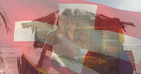 Smiling woman holding surfboard on tropical beach with lessons rentals hut and flag overlay