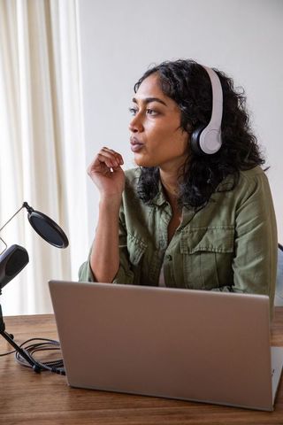 Focused African American Woman Recording Podcast in Home Office