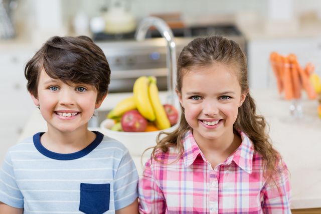 Portrait of sibling smiling in kitchen at home