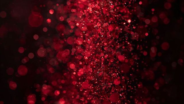 Vertical red particle column with bokeh glow, glitter sparks and shallow depth
