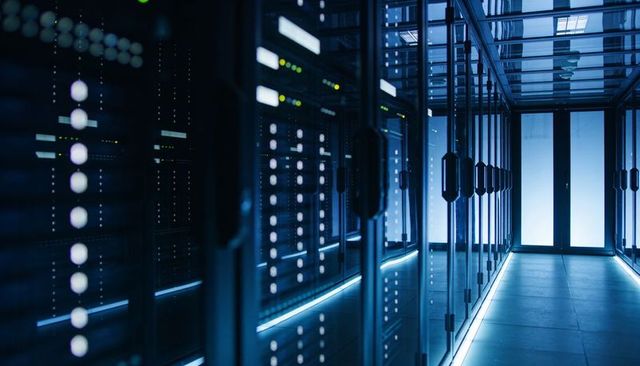 Blue-lit data center corridor featuring glass-front server racks, LED indicators, frosted doors