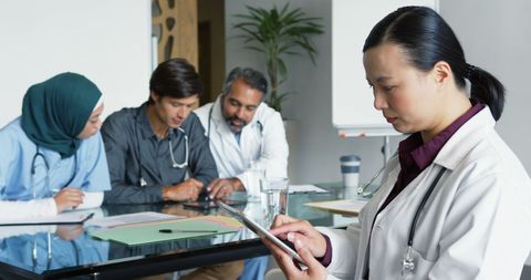 Asian Female Doctor Leading Diverse Medical Team Meeting