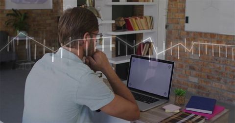 Focused professional analyzing data on laptop at modern creative desk with blank screen