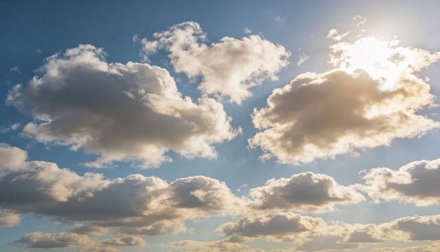 Sunlit Cumulus Clouds Drifting Over Blue Sky with Glowing Edges and Soft Backlight