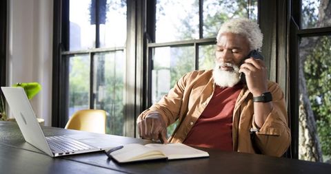 Senior Man Balances Communication and Work with Calm Efficiency