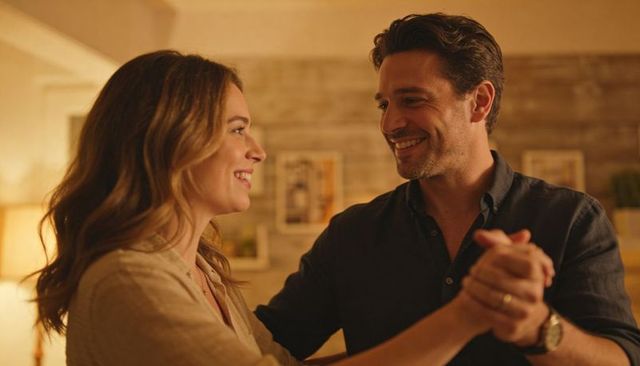 Couple dancing slowly in cozy living room during warm evening romantic home moment