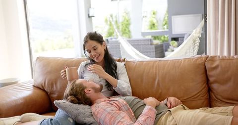 Diverse Couple Relaxing and Enjoying Comfort on Sofa