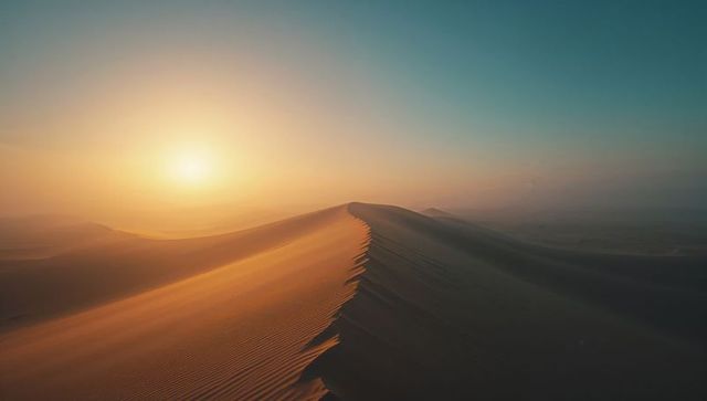 Glowing Sunrise Over Desert Sand Dunes with Wind-Sculpted Ripples