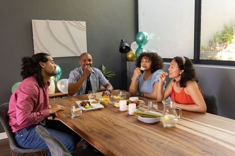 Diverse Friends Enjoying Snacks and Conversation in Modern Dining Setting