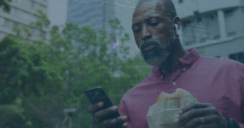 Experienced Man Analyzing Financial Data Using Smartphone