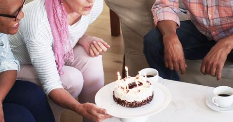 Senior Friends Celebrating with Birthday Cake and Coffee Home