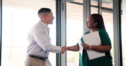 Confident business people handshaking in modern workplace