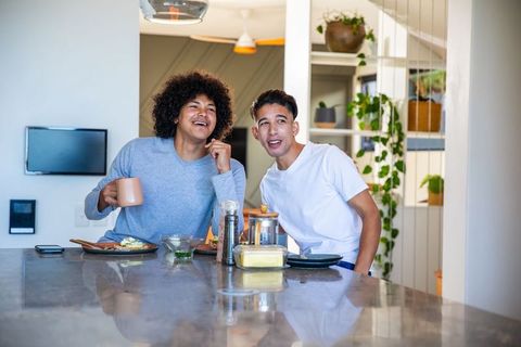 Male Friends Enjoying Breakfast and Conversation in Modern Kitchen