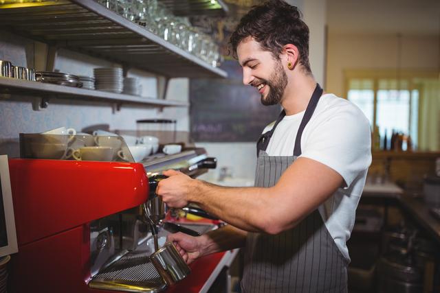 Smiling waiter making cup of coffee in cafe