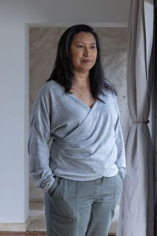 Serene Woman Relaxing by Window in Minimalist Home Interior
