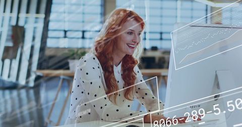 Redhead Businesswoman Analyzing Data on Computer in Modern Office