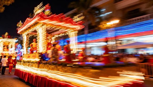 Festive holiday parade float with motion-blur light trails and costumed performers at night