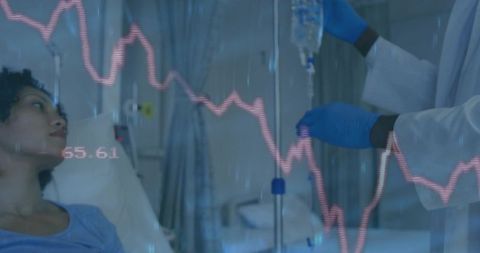 Healthcare Professional Adjusting IV with ECG Display in Hospital