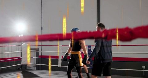 Boxer Sparring with Coach in Ring Wearing Blue Headgear and Black Shorts During Training