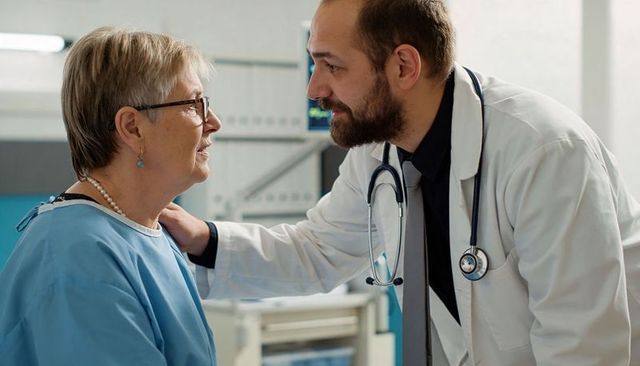 Doctor comforting senior patient during consultation showing empathy and compassionate care