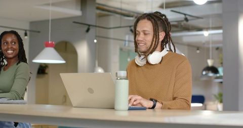 Coworking professionals collaborating in modern minimalist office with laptop and headset