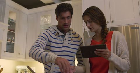 Couple Cooking Together with Tablet in Modern Kitchen