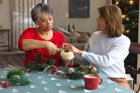 Senior women crafting holiday wreaths in cozy christmas setting