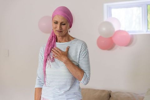 Senior woman in pink headscarf celebrating at home