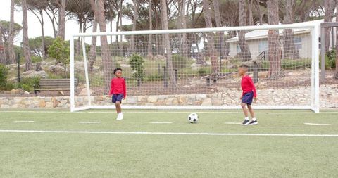 Young Boys Playing Soccer on Turf Field in Athletic Apparel