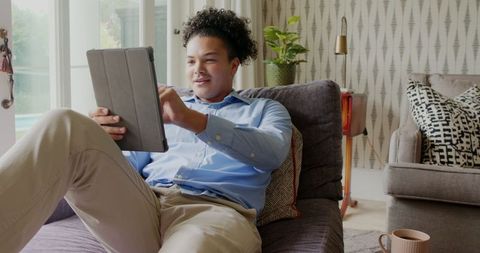 Young Man Relaxing at Home with Tablet