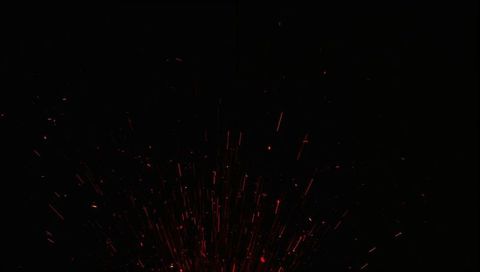 Red-Orange Sparks Radiating Upward with Streaking Ember Trails on Deep Black Background