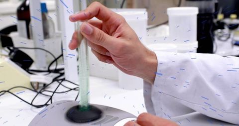 Laboratory technician inserting glass tube into vortex mixer for precise sample mixing