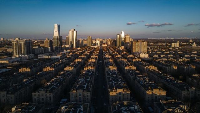 Central avenue stretching toward glass highrises during golden hour in urban grid